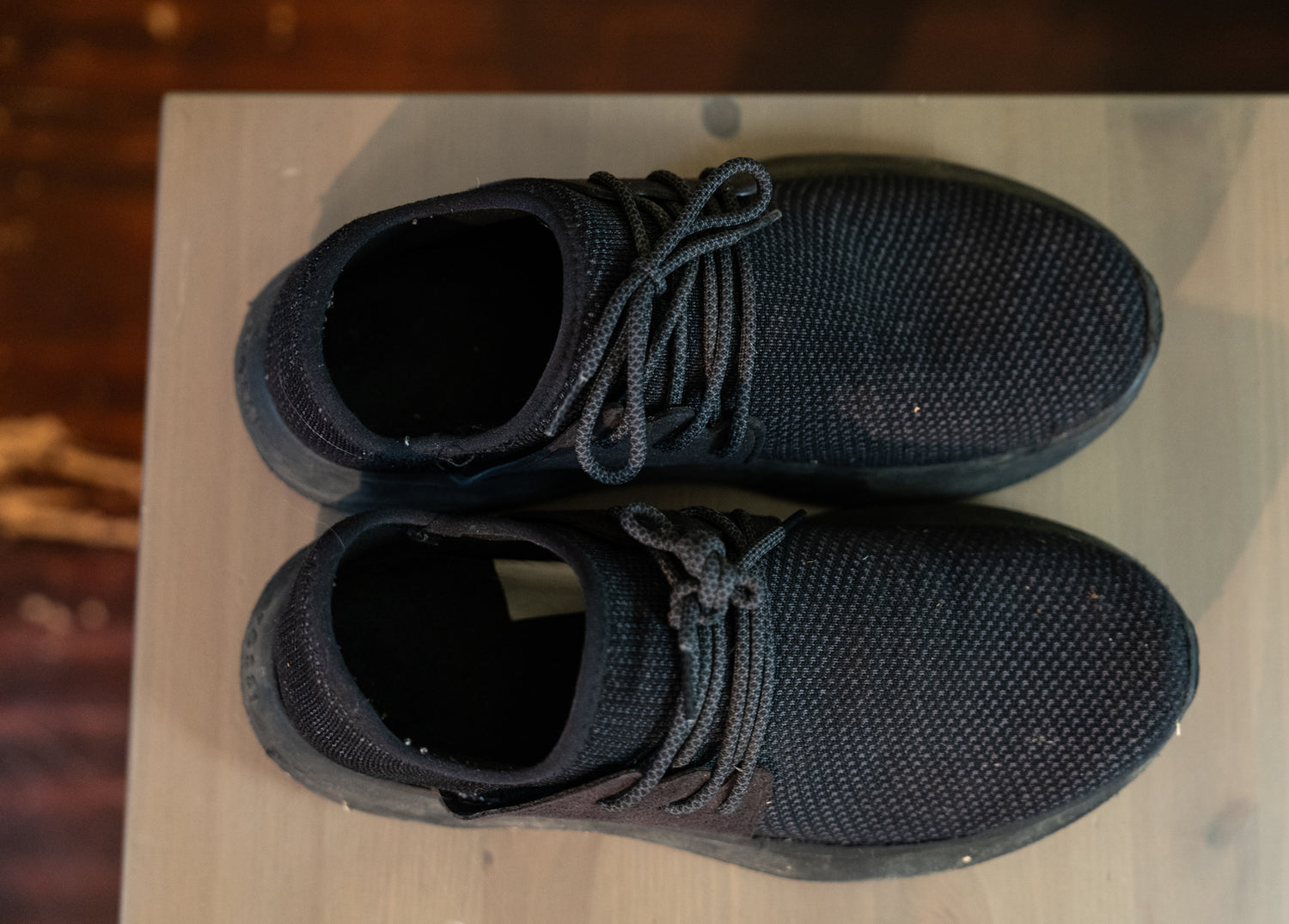 Pair of black knit shoes on a table top