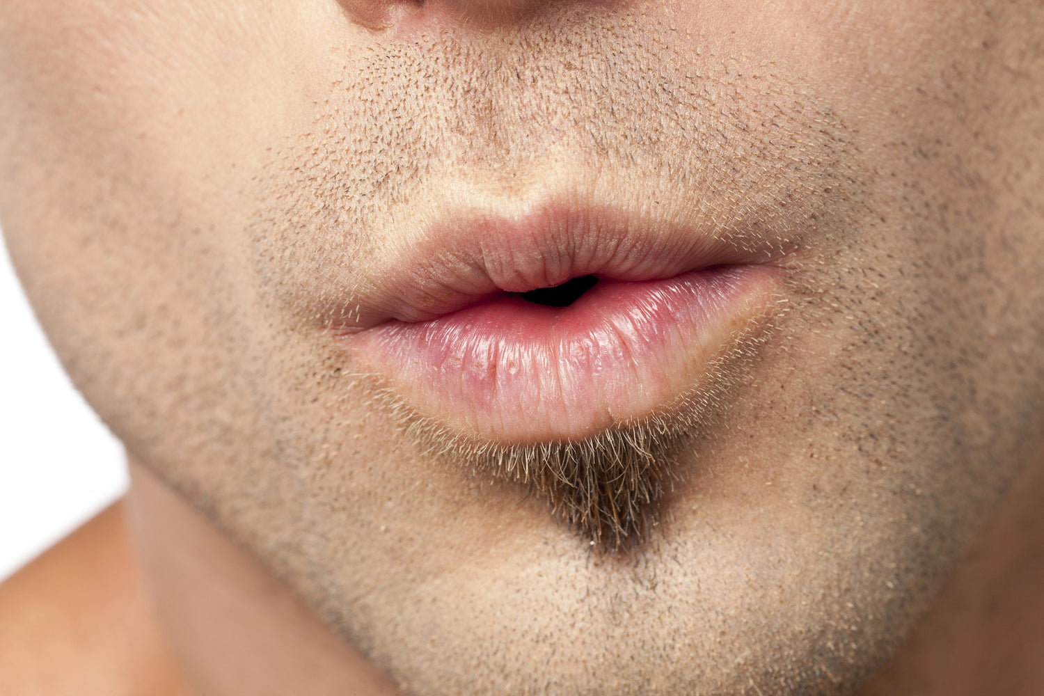 Close-up of a man's lips whistling with a neutral background