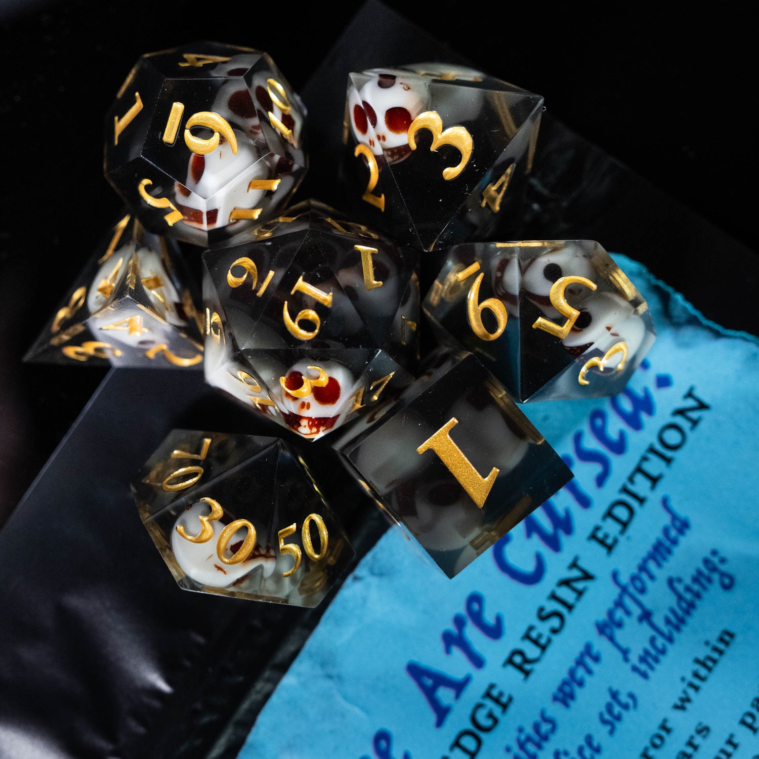 cursed black sharp edge resin skull design dungeons and dragons (aka dnd or d&d) game dice set, including a d20, d12, d10, d8, d6, and d4