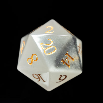 Translucent white glass gemstone dungeons and dragons (aka dnd or d&d) d20 game die or dice with gold numbers on a black background