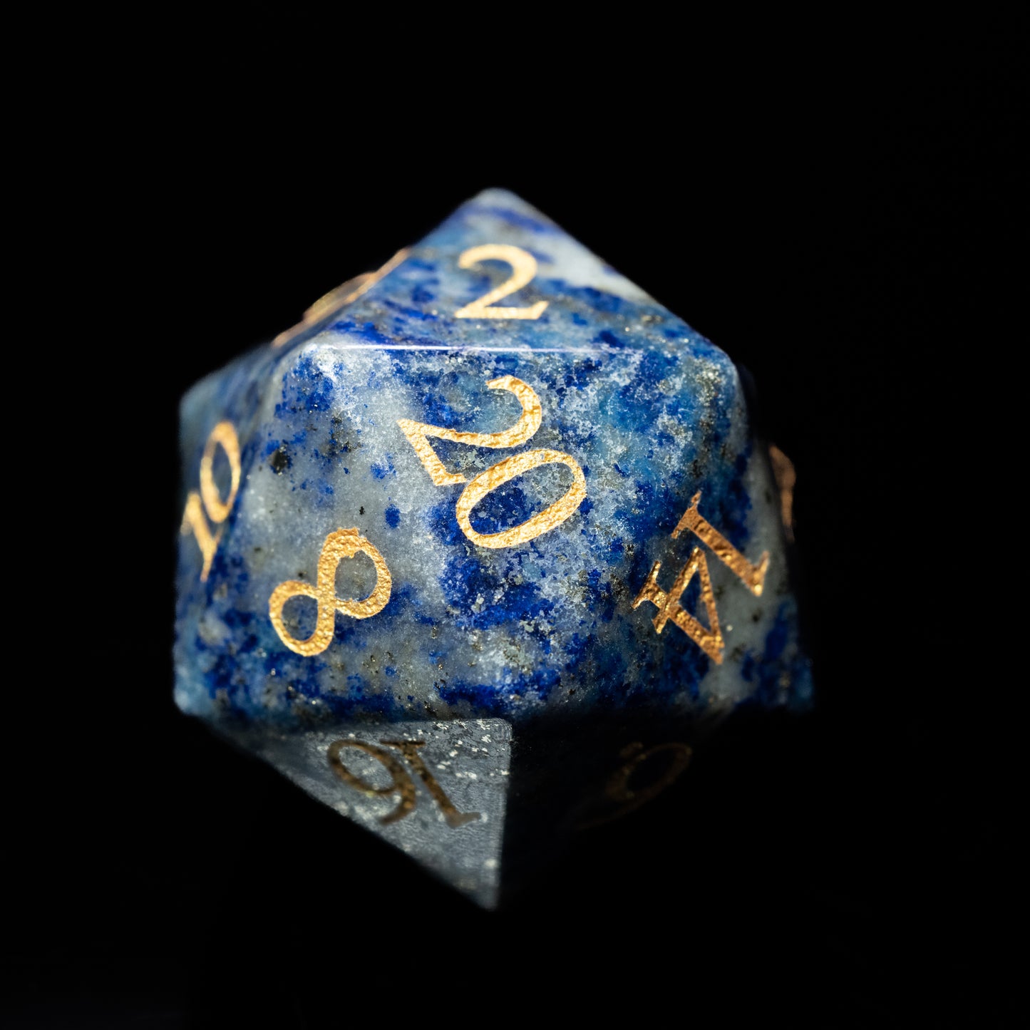 Blue granite glass gemstone dungeons and dragons (aka dnd or d&d) d20 game die or dice with gold numbers on a black background