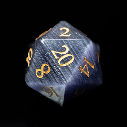 blue cat's eyeglass gemstone dungeons and dragons (aka dnd or d&d) d20 game dice or die with gold numbers on a black background